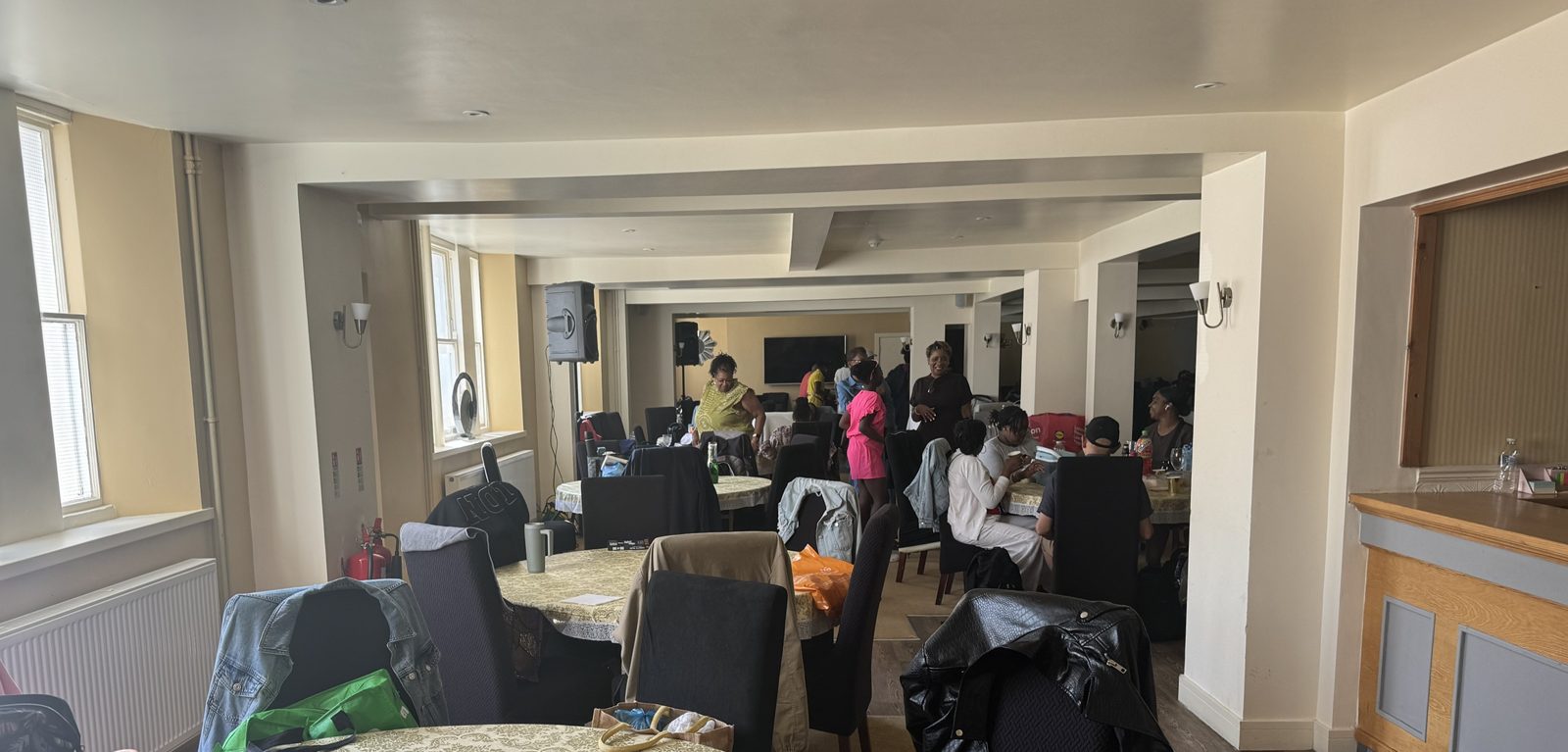 A function room with round tables where guests are gathered and talking